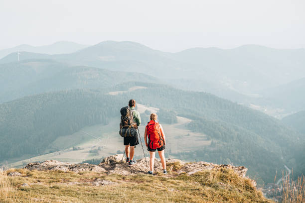 istock Hiking friends relax at viewpoint on mountain ridge 1352420210