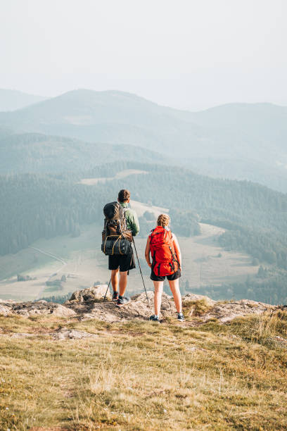 istock Hiking friends relax at viewpoint on mountain ridge 1352420217