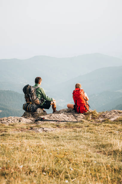 istock Hiking friends relax at viewpoint on mountain ridge 1352420218