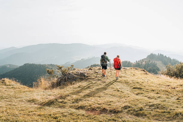 widok przyjaciół wędruczucych trawiastym grzbietem górskim - hiking young women outdoors t shirt zdjęcia i obrazy z banku zdjęć