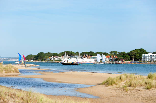 Poole Harbour entrance over the dunes at Shell Bay near Studland, Dorset, England, UK. Poole Harbour entrance over the dunes at Shell Bay near Studland, Dorset, England, UK. A recreational hub on the south coast of England, Poole harbour, the second largest natural harbour in the world, attracts tourists, yachtsmen, hikers and horseriders alike in pursuit of leisure activities along the coastline and water's edge. studland heath stock pictures, royalty-free photos & images