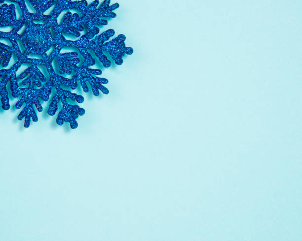 istock Blue toy snowflake glitter shiny on blue background with copyspace postcard 1352420723