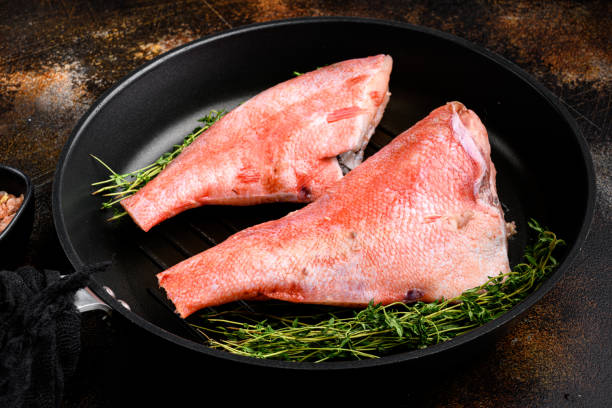 raw fillet of red sea perch, in frying cast iron pan, on old dark rustic table background - rockfish imagens e fotografias de stock