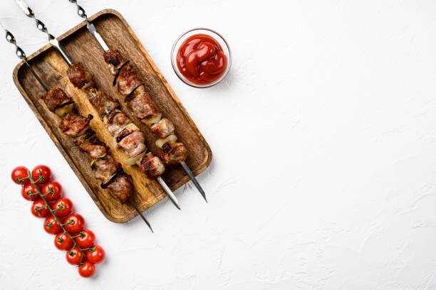 istock Kebabs grilled meat skewers, shish kebab, on white stone table background, top view flat lay, with copy space for text 1352421636