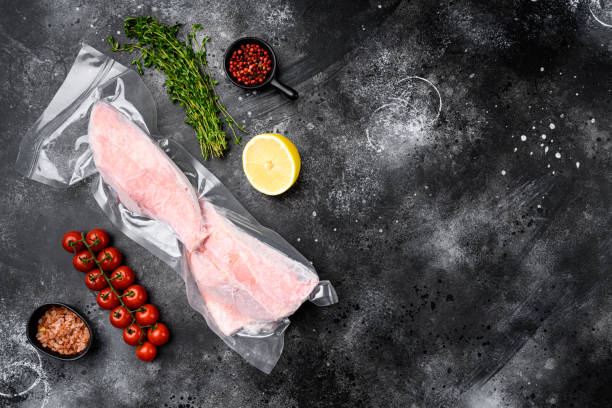 istock Perch frozen fish meat pack , with herbs, on black dark stone table background, top view flat lay, with copy space for text 1352421754