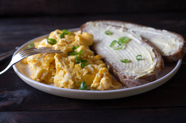яичница с масляным хлебом - fork plate isolated scrambled eggs стоковые фото и изображения