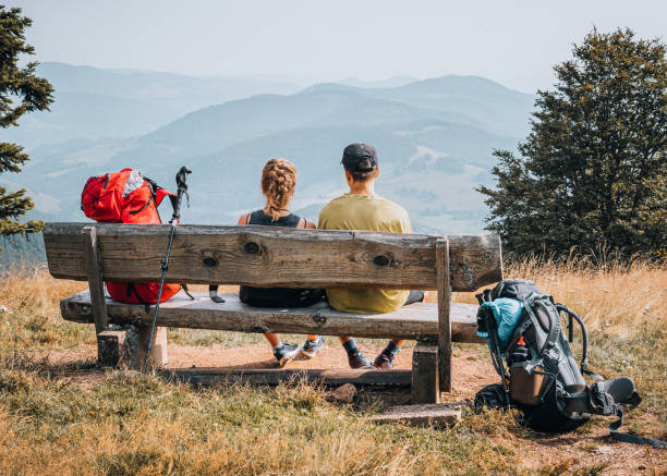 istock Hiking friends relax on grassy mountain ridge 1352422784