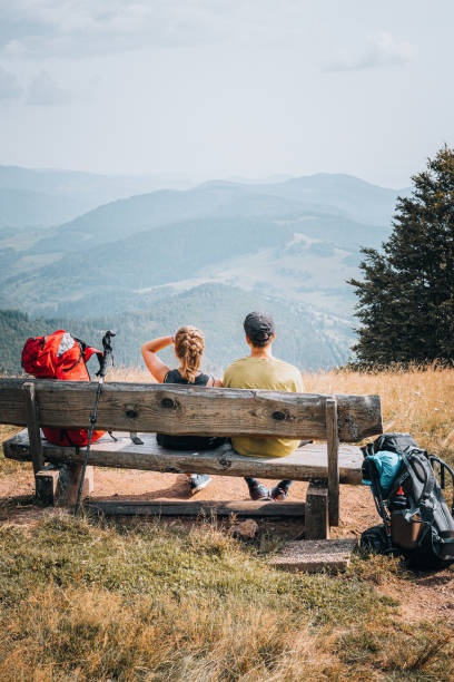 istock Hiking friends relax on grassy mountain ridge 1352422793
