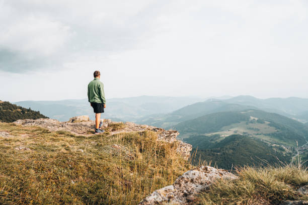 istock View of hiker relaxing on grassy mountain ridge 1352422875