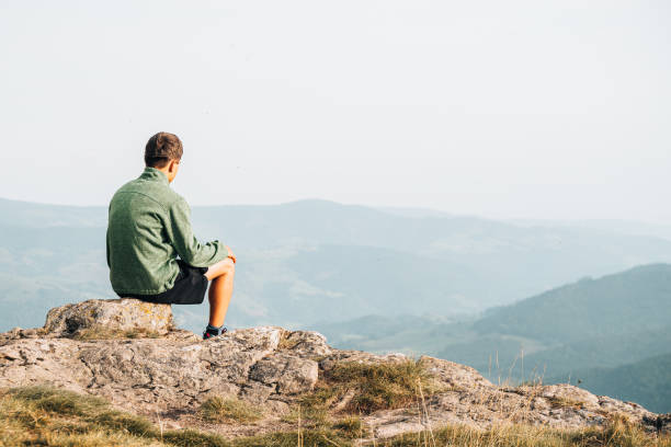 istock Hiker relaxes at viewpoint on grassy mountain ridge 1352422902