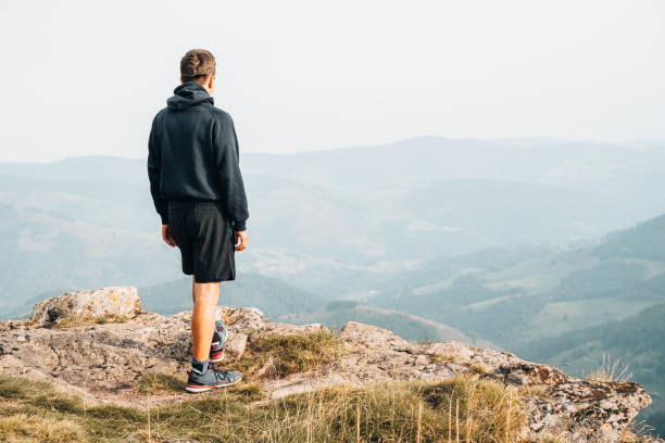 istock Hiker relaxes at viewpoint on grassy mountain ridge 1352422906