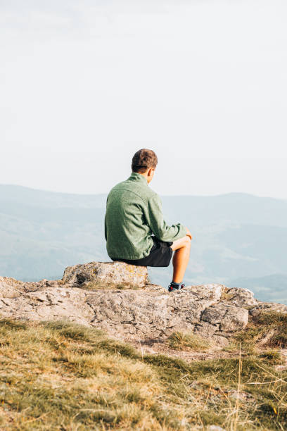 istock Hiker relaxes at viewpoint on grassy mountain ridge 1352422912