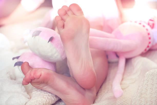 Bare feet, relaxing with toy. Lazy holiday concept