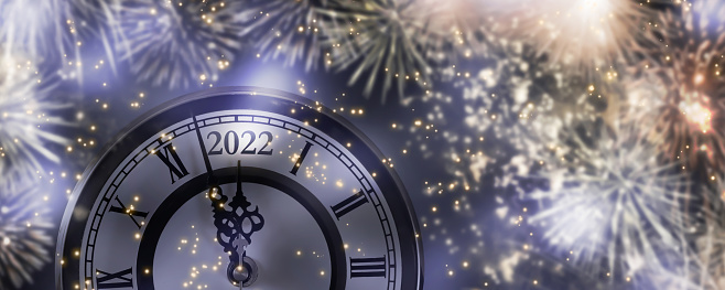 fireworks around the countdown clock 2022 at midnight, cheerful new year's eve party with firecrackers explosion at the night sky, beautiful celebration concept for happy new year 2022 at twelve