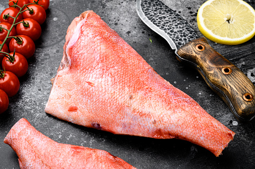 Fresh red perch or sea bass set, on black dark stone table background