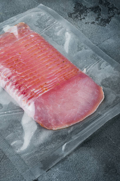 istock Cured pork meat or prosciutto, vacuum packed, on gray stone background 1352426385