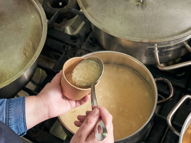 istock Woman pouring soup on takeaway containers 1352426430