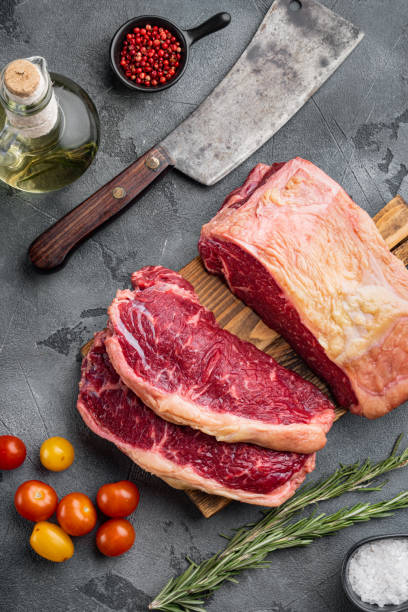 bistecca club disossata di manzo fresco, su sfondo grigio, vista dall'alto - strip steak steak beef raw foto e immagini stock