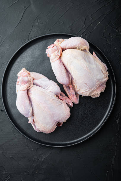 istock Raw small young chicken, on black background 1352427624