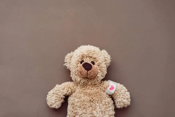 Vaccination, sick, childhood, plushy, soft, brown background, copy space