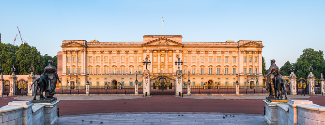 Warm sunlight of daybreak illuminating the iconic facade of Buckingham Palace at the end of The Mall in the heart of London, UK.