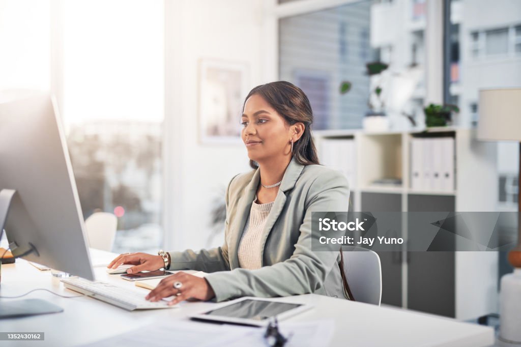 Shot of an attractive young businesswoman sitting in the office and using her computer Business has advanced with technology Desktop PC Stock Photo