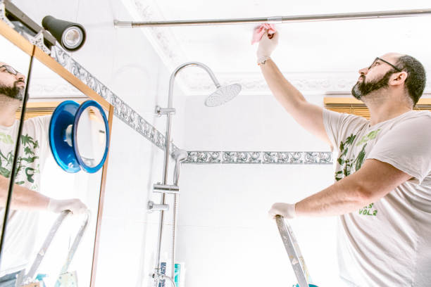 Adult man with beard cleaning mold stains from bathroom.