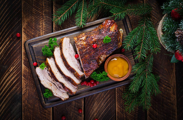 Baked pork belly with herbs. Boiled pork. Festive Christmas table. Top view, overhead stock photo