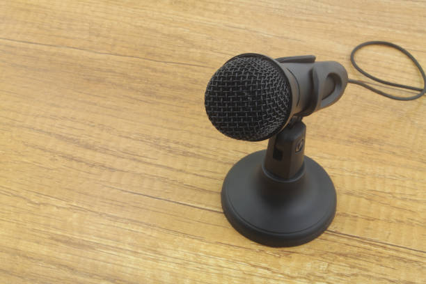 istock Black microphone on stand on wooden table. 1352436818