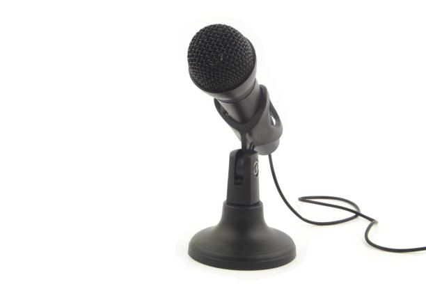 istock Black microphone with cord on stand isolated on white 1352436940