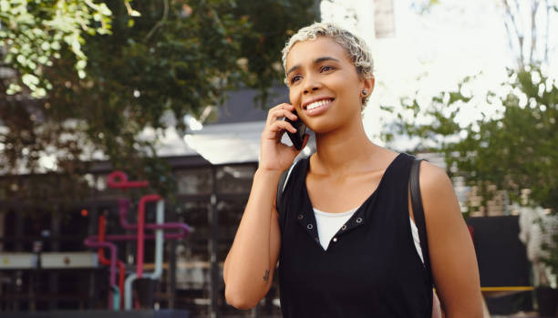 istock Shot of a young woman using her cellphone while walking outside 1352437862