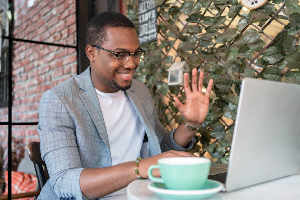 istock Man On A Video Conference Call At Coffee Shop 1352438636
