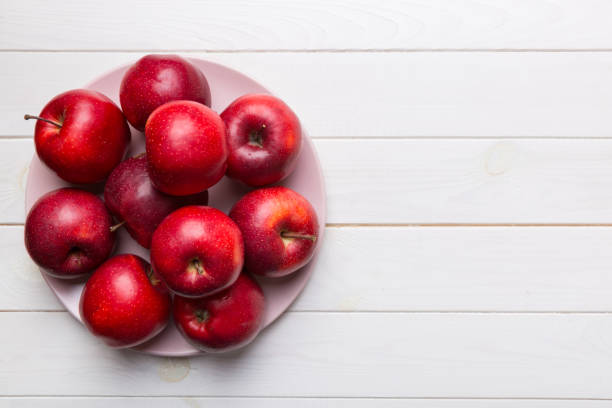 istock juicy red apples in a bowl or plate on the table top view. Copy space 1352439685
