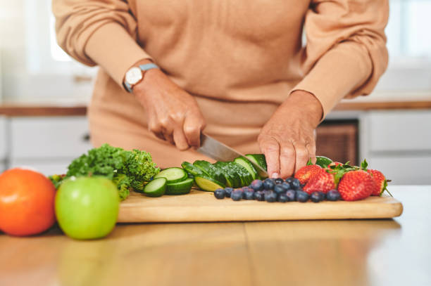 tiro de uma mulher irreconhecível cortando comida em uma cozinha - cucumber vegetable close up fruit - fotografias e filmes do acervo