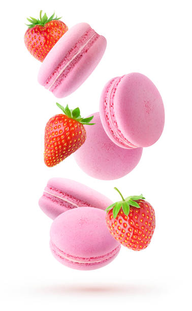 istock Falling pink macaroons and fresh straberries isolated on white background 1352442538