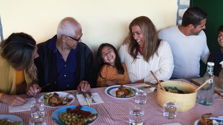 Happy latin family eating dinner at vintage restaurant terrace