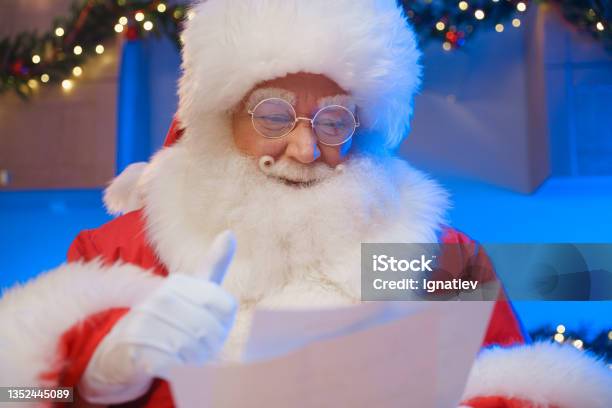 Portrait Of Santa Claus Reading A Letter Santa Claus Holds His Thumb Up With This Gesture He Shows That He Really Likes The Letter Sent Santa Claus Loves When Children Compose Poems About Him Stock Photo - Download Image Now