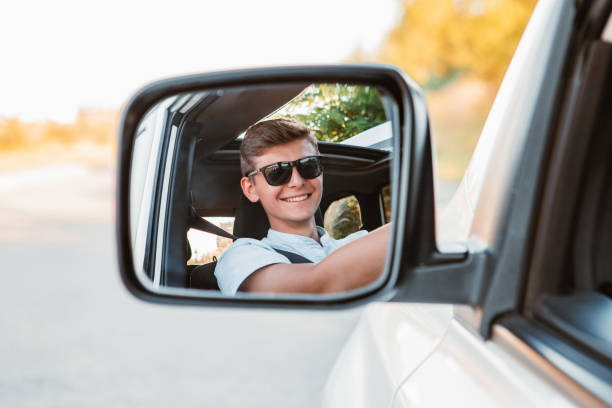 young handsome confident man driving car stock photo