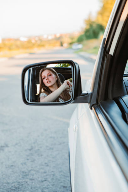 istock young pretty woman driving car on sunset 1352445370