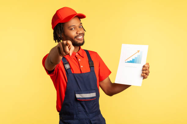 handyman mantém gráfico mostrando aumento dos salários dos trabalhadores, convidando-o a trabalhar no setor de serviços. - coveralls professional occupation manual worker service occupation - fotografias e filmes do acervo