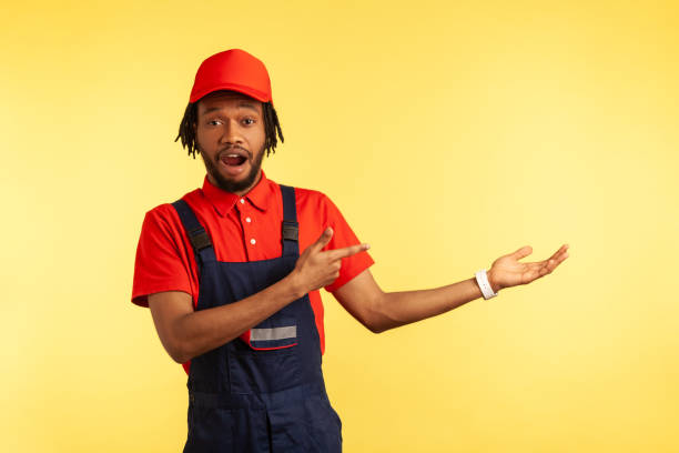 istock Worker presenting copy space for advertisement, pointing finger aside, ad of delivery service. 1352445812