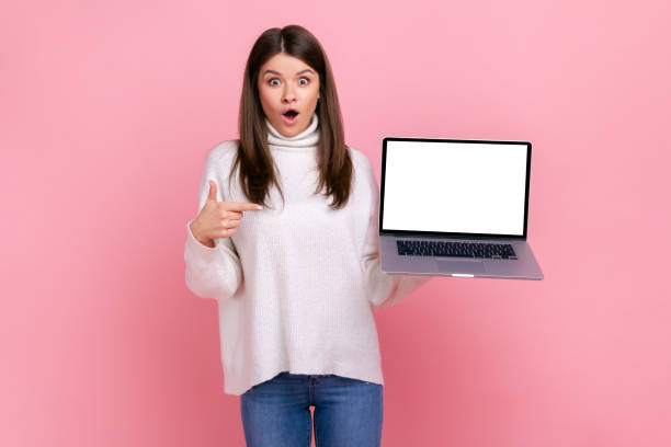istock Shocked astonished female pointing at laptop display with blank white display for advertisement. 1352446371