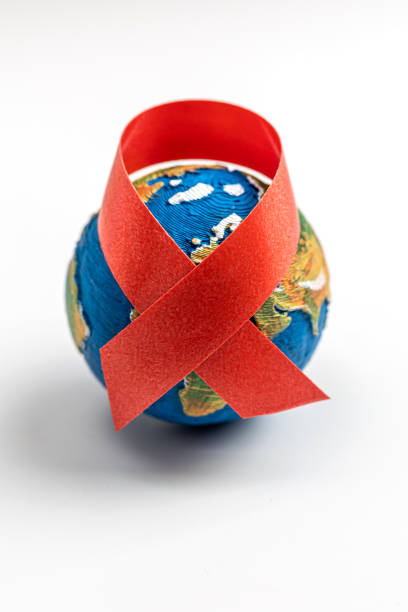 Earth model and red ribbon The red ribbon is an international symbol of HIV and AIDS awareness world aids day stock pictures, royalty-free photos & images