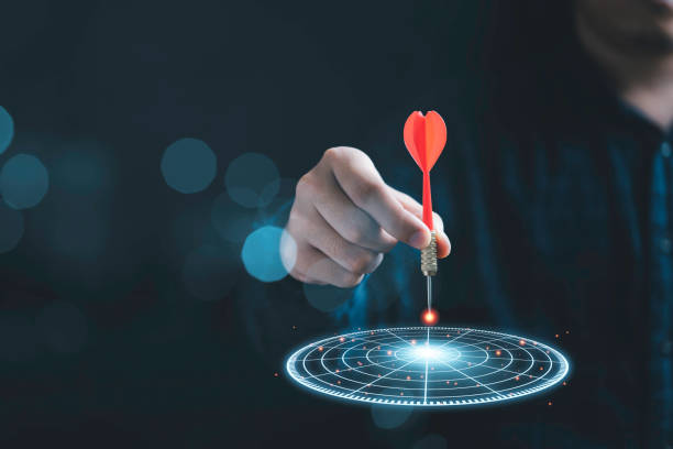 istock Businessman throwing red arrow dart to virtual target dart board. Setup objectives and target for business investment concept. 1352449138