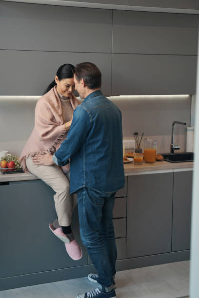 istock Loving mature couple cuddling during morning in kitchen 1352452682