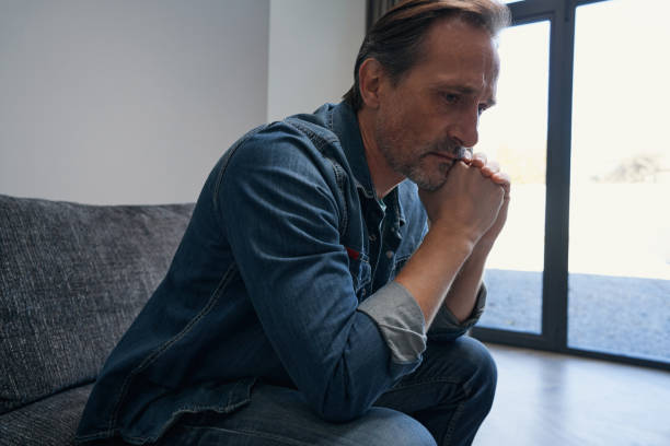 istock Sad mature male on couch at home 1352452686