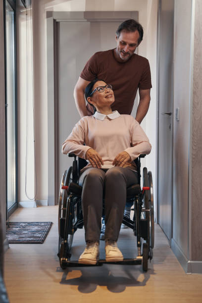 istock Caring man assisting smiling woman with disability indoors 1352452777