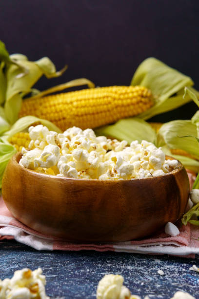 istock Fresh corn and popcorn on cobs on black background. Vertical photo. Copyspace 1352453417