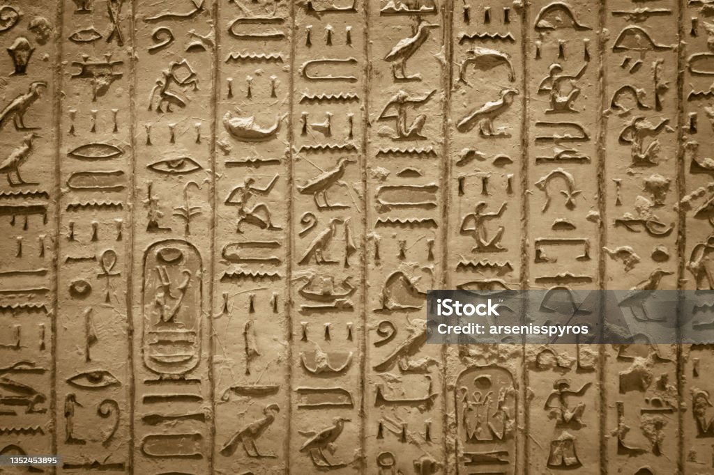 Hieroglyphics of ancient Egypt carved on sandstone wall Ancient Egyptian Culture Stock Photo