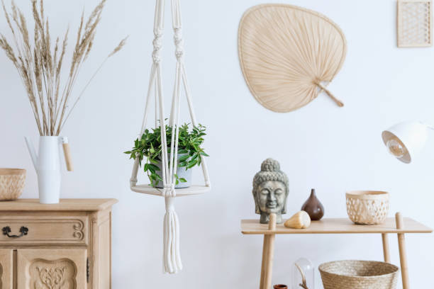 Stylish and boho home interior of open space with wooden desk, chair, lamp and white shelf. Design and elegant personal accessories. Botany and minimalistic. home decor. Abstract painting on the wall. Template. interior de casa elegante y boho de espacio abierto con escritorio de madera, silla, lámpara y estante blanco. diseño y elegantes accesorios personales. botánica y minimalista. decoración del hogar. pintura abstracta en la pared. plantilla.